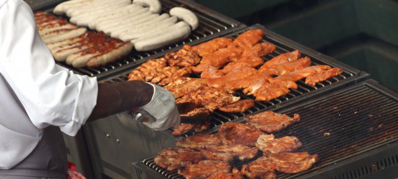 Hähnchenschnitzel und Würste auf einem Grill