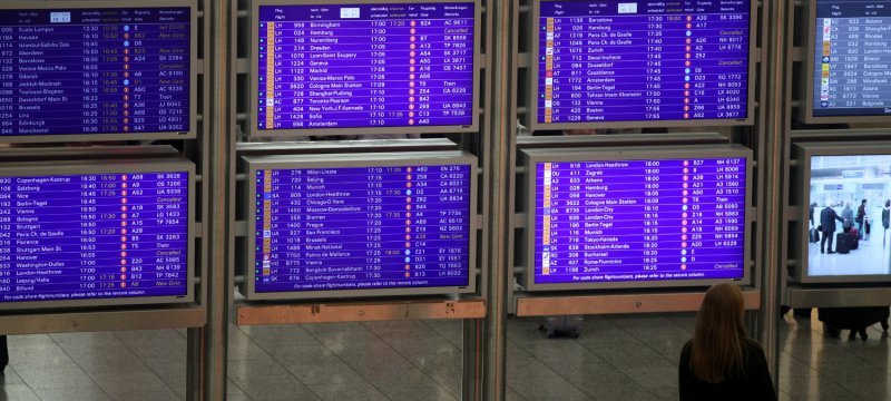 Frau vor Informationstafel am Frankfurter Flughafen