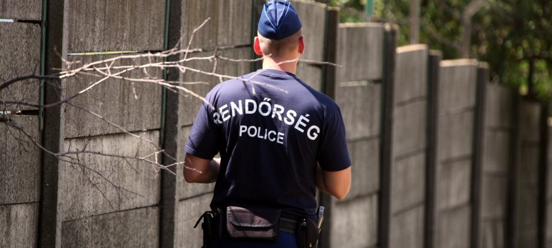 Ungarische Polizei an einer Mauer mit Stacheldraht