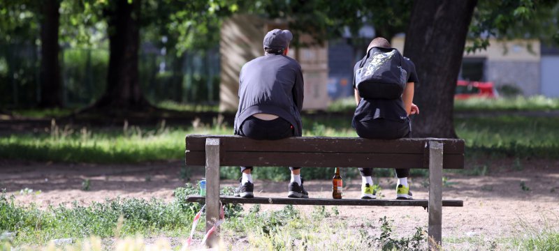 Jugendliche auf einer Parkbank mit Bier