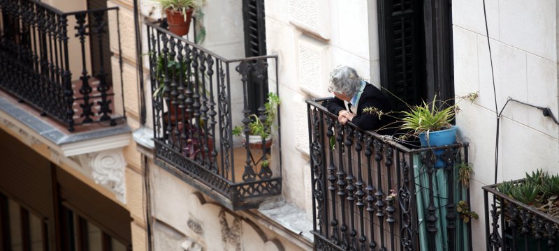 Seniorin schaut von einem Balkon