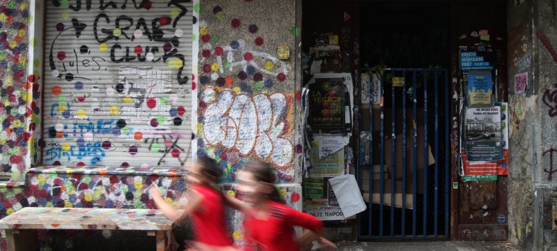 Kinder vor einem unsanierten Haus in Berlin-Neukölln